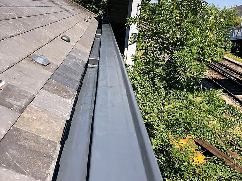 A lead lined valley gutter beside a tiled roof slope