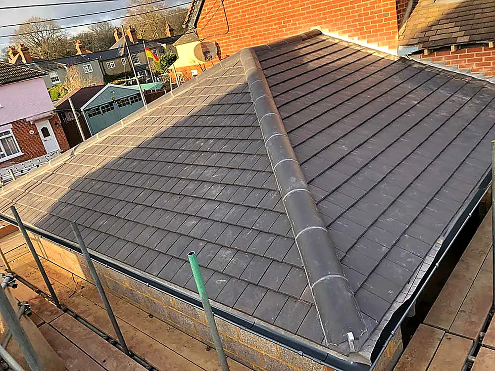 A newly tiled hipped roof with the scaffold still in place